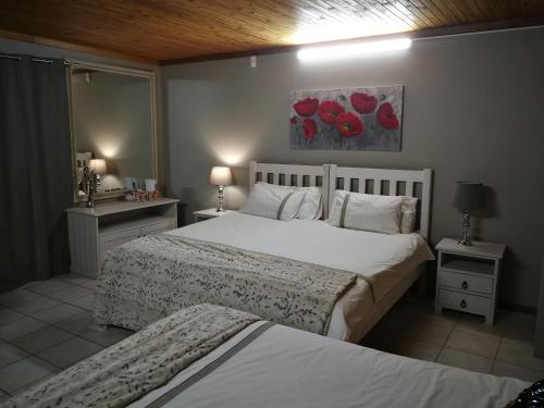 a bedroom with two beds and two tables and two lamps at Chic Breeze in Bloemfontein