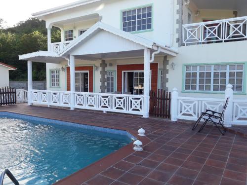 a house with a swimming pool in front of a house at Bonne View Villa in Rodney Bay Village