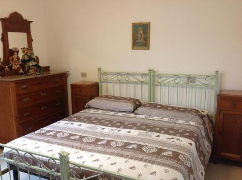 a bedroom with a green bed and a dresser at Castel Di Gufi in Comano