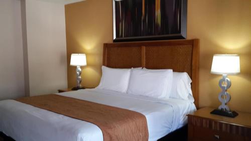una camera d'albergo con un grande letto con due lampade di American Regency Inn a Williams