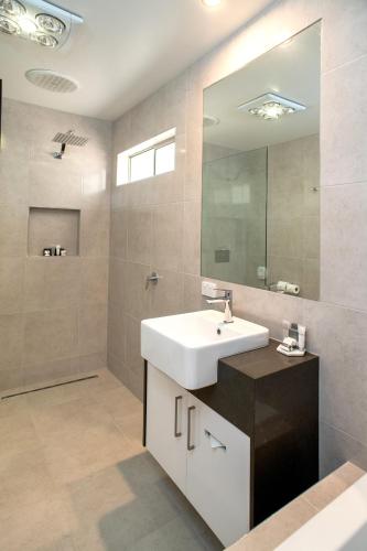 a bathroom with a white sink and a mirror at Tea House Motor Inn in Bendigo