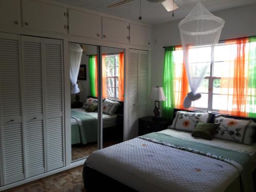 1 dormitorio con cama y espejo en Bonne View Villa, en Rodney Bay Village