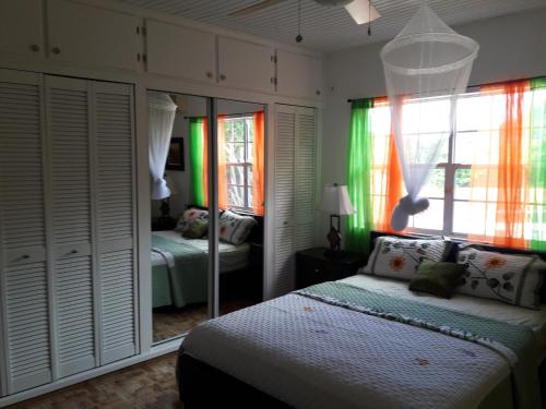 a bedroom with a bed and a mirror at Bonne View Villa in Rodney Bay Village