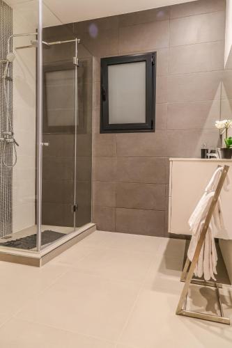 a bathroom with a shower and a television on the wall at A&M House II Luxury Holidays Home in Arco da Calheta