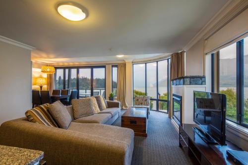 a living room with a couch and a flat screen tv at Peppers Beacon in Queenstown