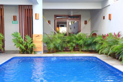 a large blue swimming pool in front of a house at Punta Zicatela Hotel - Adults Only in Puerto Escondido
