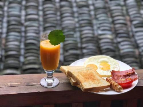 a plate of breakfast food with a glass of orange juice at Yangshuo Secret Garden in Yangshuo