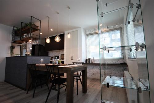a dining room and kitchen with a table and chairs at TEINE WHITE HOUSE in Sapporo