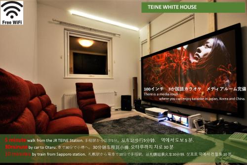 a living room with a tv and a red chair at TEINE WHITE HOUSE in Sapporo