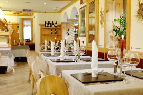 a room with tables and chairs with wine glasses at Boutique Hotel Diana in Madonna di Campiglio