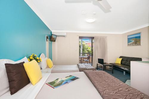 Habitación de hotel con cama y sala de estar. en Byron Bayside Central Studio Apartments, en Byron Bay