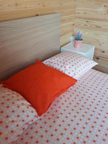 a bed with orange and white pillows in a room at Cyprus Glamping Park in Ayios Theodhoros