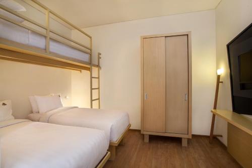 a bedroom with two beds and a bunk bed at MaxOneHotel Tidar Surabaya in Surabaya