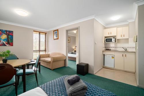 a living room with a kitchen and a dining room at Garden City Motor Inn in Wagga Wagga