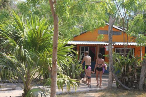a family walking outside of a house at Eco Hotel Las Palmeras in Isla Grande