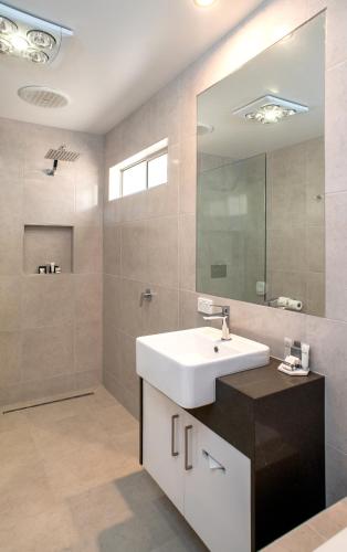a bathroom with a sink and a mirror at Tea House Motor Inn in Bendigo