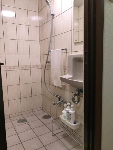 a bathroom with a shower and a sink at Takana in Nago