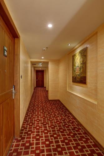 an empty hallway with a painting on the wall at JVK Park Hotel in Cochin