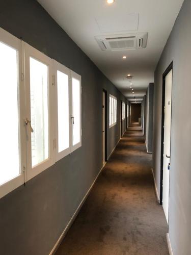 an empty hallway with windows and a long corridor at Rest Chinatown Hotel in Singapore