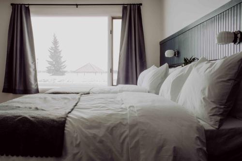 a bedroom with a large bed with white sheets and a window at The Bayview Motel - Fort Frances, ON - Lakeside Motel in Fort Frances