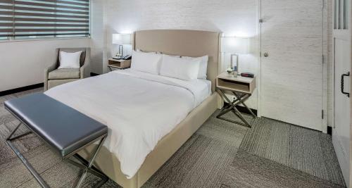 a bedroom with a large bed and a chair at The Rushmore Hotel & Suites; BW Premier Collection in Rapid City