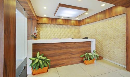 a lobby with a wooden door and two potted plants at Itsy By Treebo - Jansi Residency in Coimbatore