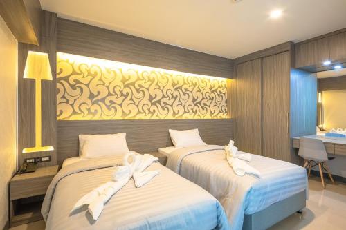 a bedroom with two beds with white bows at Sound@sleep Hotel in Bangkok