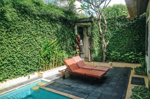 a brown chair sitting next to a swimming pool at The Lagoon Bali Pool Hotel and Suites in Legian