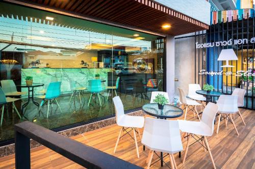 a restaurant with tables and chairs in front of a window at Sound@sleep Hotel in Bangkok