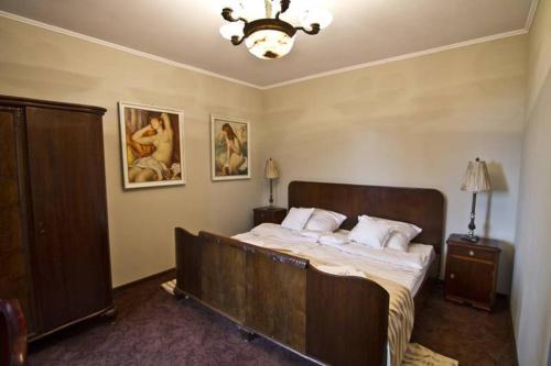 a bedroom with a large bed and a chandelier at Leniwka in Świebodzin