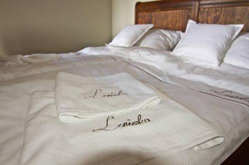 two towels are sitting on a white bed at Leniwka in Świebodzin