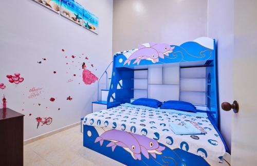 una camera da letto con un letto blu con sopra del pesce di Esdi Homestay Malacca a Malacca