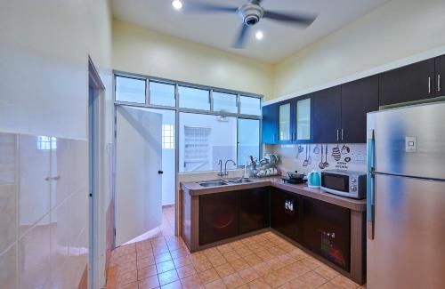 a kitchen with a stainless steel refrigerator and a sink at Esdi Homestay Malacca in Malacca