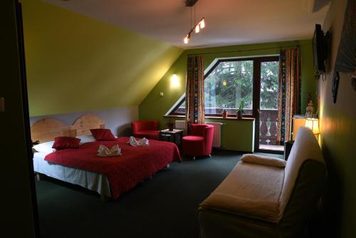 ミエンジグジェにあるWilla Pod Dobrym Humoremのベッドと椅子、窓が備わるホテルルームです。