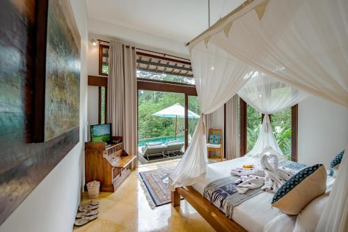 Schlafzimmer mit einem Himmelbett und Poolblick in der Unterkunft Villa Umah Shanti in Ubud