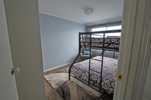 a bedroom with a bunk bed in a room at Stunning Waterfront only 10 minutes to Phillip Island - FREE EV UNIT 7kW for electric cars - pet friendly, fireplace FREE WIFI wine & chocolates in Kilcunda