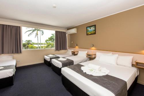 um quarto de hotel com duas camas e uma janela em Mid City Motor Inn em Mackay