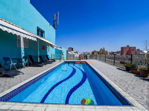 una piscina con un edificio azul y un azul en San Marino Hotel, en Dubái