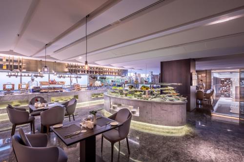 a restaurant with tables and chairs and a kitchen at Braira Al Nakheel in Riyadh