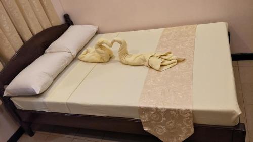 Una cama con dos animales tallados. en Dumdum Medical Plaza and Residences en Toledo City