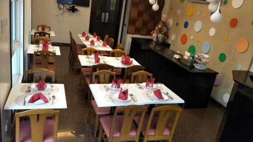 una fila de mesas en un restaurante con servilletas rojas. en Dumdum Medical Plaza and Residences en Toledo City