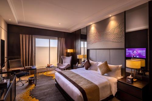 a hotel room with a bed and a flat screen tv at Braira Al Nakheel in Riyadh