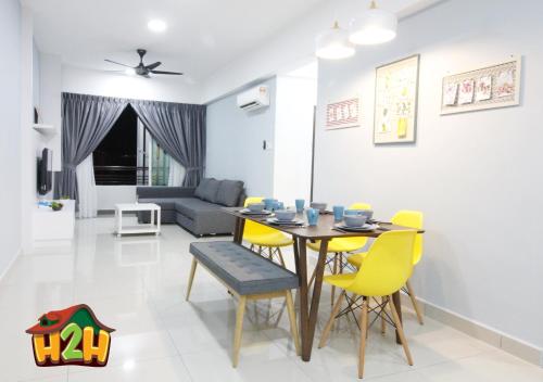 a dining room and living room with a table and chairs at H2H - TT Court Majestic Ipoh in Ipoh