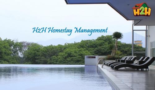 a swimming pool with chairs next to a body of water at H2H - TT Court Majestic Ipoh in Ipoh