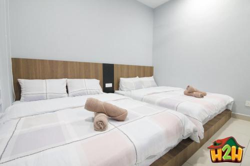 two beds in a room with two teddy bears on them at H2H - TT Court Majestic Ipoh in Ipoh