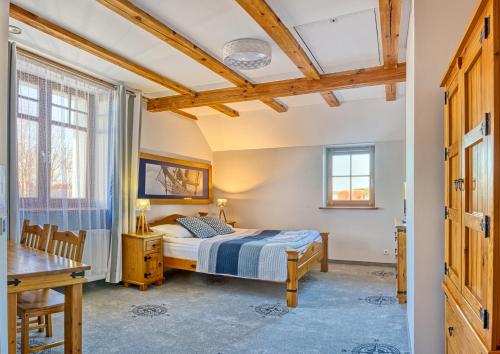 1 dormitorio con 1 cama y 1 mesa en Hotel Joseph Conrad, en Pisz