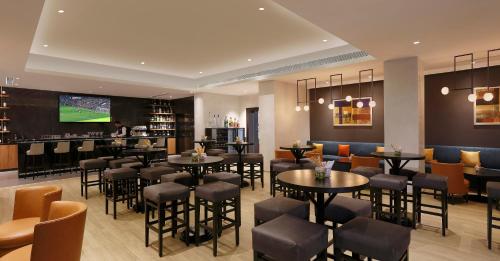 a restaurant with tables and chairs and a tv at Novotel Hyderabad Convention Centre in Hyderabad