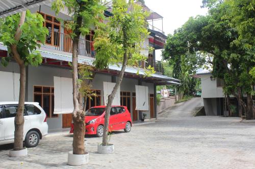 a red car parked in front of a building at Pondok Wisata dan Restoran Elim in Waingapu