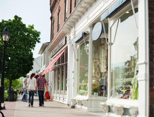 people walking down a sidewalk in front of a store at Queens Landing in Niagara on the Lake
