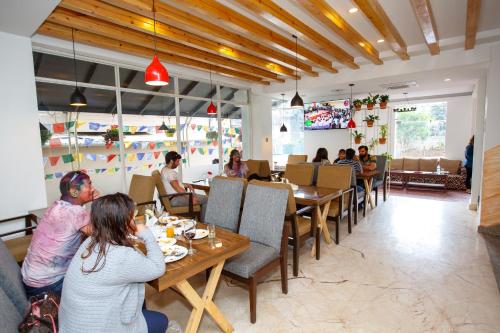 a group of people sitting at tables in a restaurant at Beautiful Kathmandu Hotel in Kathmandu
